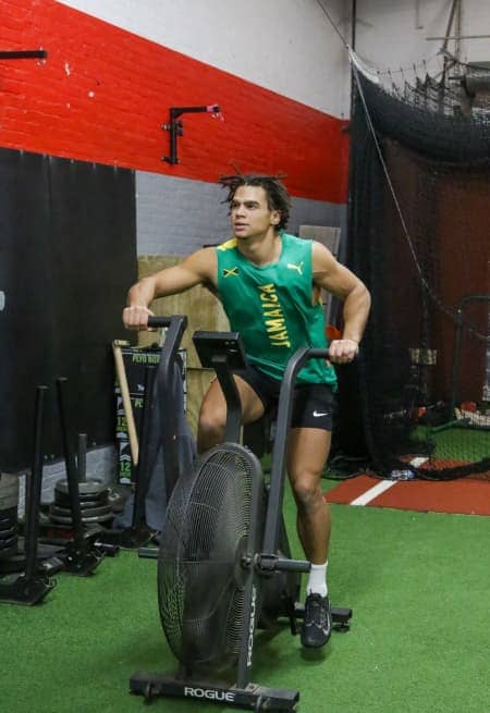 Focused individual on an air bike during Apex Performance Gym's cross-training class, exemplifying high-intensity workout.