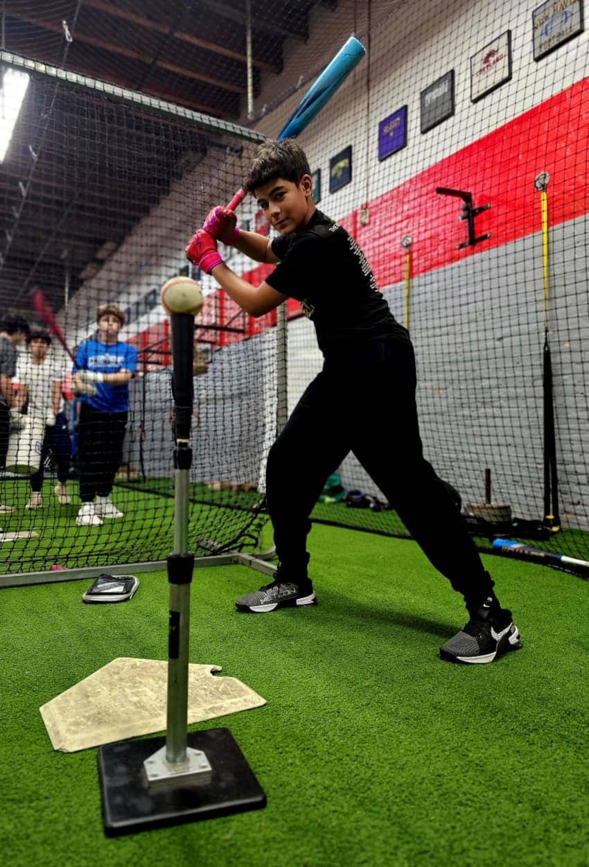 Young athlete engaged in baseball training at Apex Performance Gym's well-equipped indoor facility